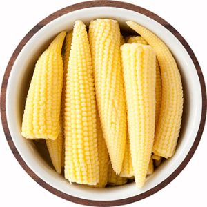 Top view of white bowl full of baby corn